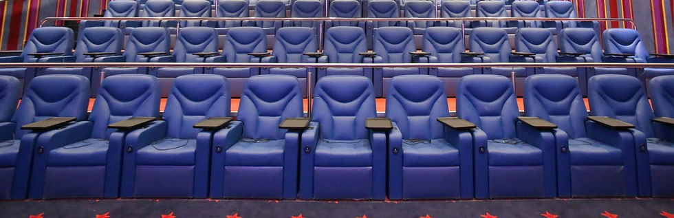 אולם Cinema Prime: שורות כורסאות כחולות נפתחות עם שולחן קטן ליד כל כורסה