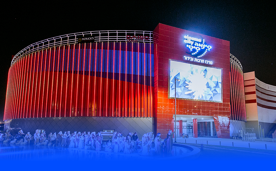 מתחם סינמה סיטי באר שבע מואר באדום בלילה עם מסך ענק